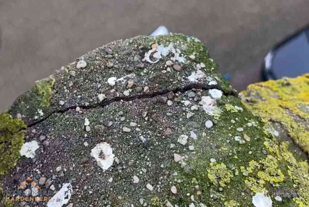 Beschadigde en verweerde nokvorst met scheuren en mos in Hardenberg