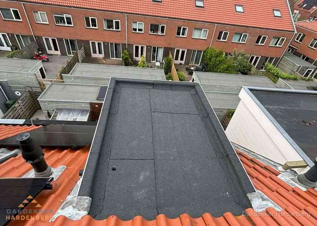 Plat dak met bitumen bedekking naast dakkapel in Hardenberg