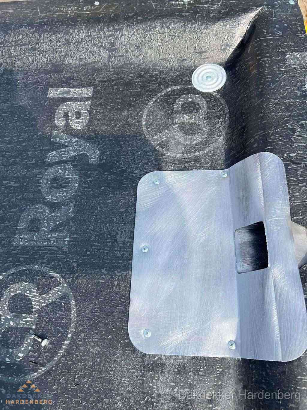 Dakdoorvoer met metalen afvoerplaat op bitumen dak in Hardenberg