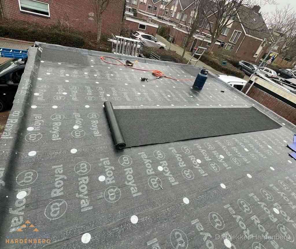 Dakdekker aan het werk met gasbrander op plat bitumen dak in Hardenberg